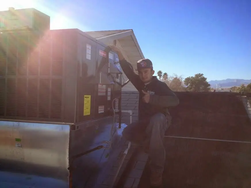 HVAC technician performing HVAC Inspection on a rooftop unit in Blue Springs